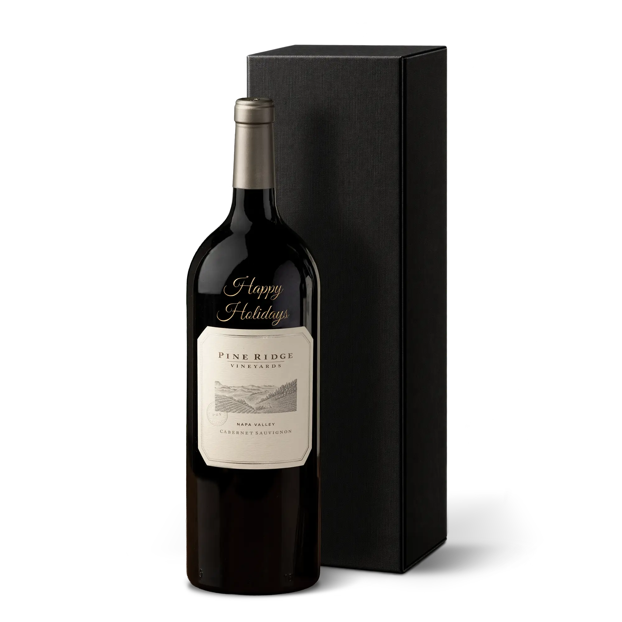 A bottle of 2023 Cabernet Sauvignon Etched Happy Holidays Magnum from Pine Ridge Vineyards stands next to a tall, rectangular black gift box on a white background.