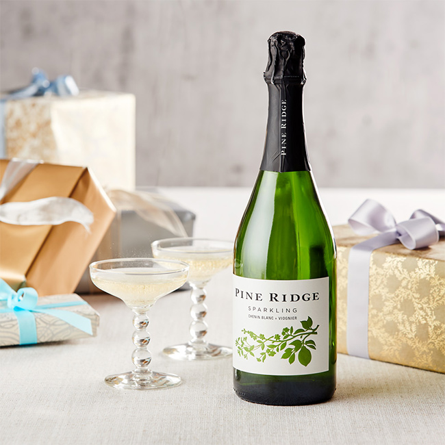 Pine Ridge Vineyards Sparkling CB+V bottle with glasses and gifts on a table