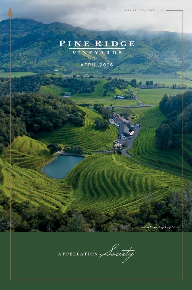 Aerial view of Pine Ridge Vineyards in Napa Valley with green rolling hills, a pond, trees, and vineyard buildings. Text overlay includes April 2026 and Appellation Society.